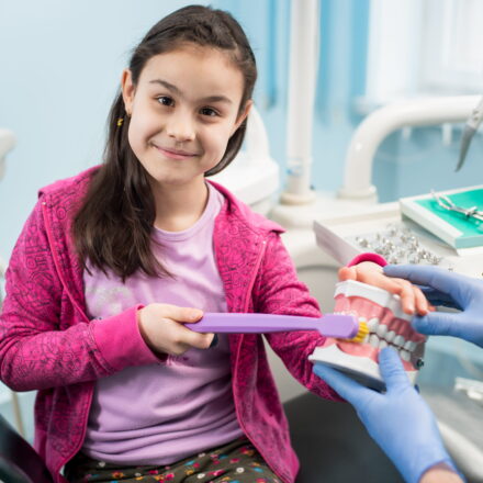 girl in dentist chair showing proper tooth brushin 2026 01 07 00 59 04 utc 1