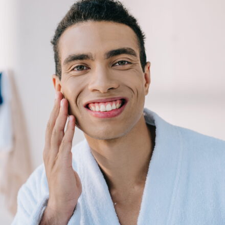 handsome man in bathrobe touching face while smili 2026 01 05 23 57 28 utc 1